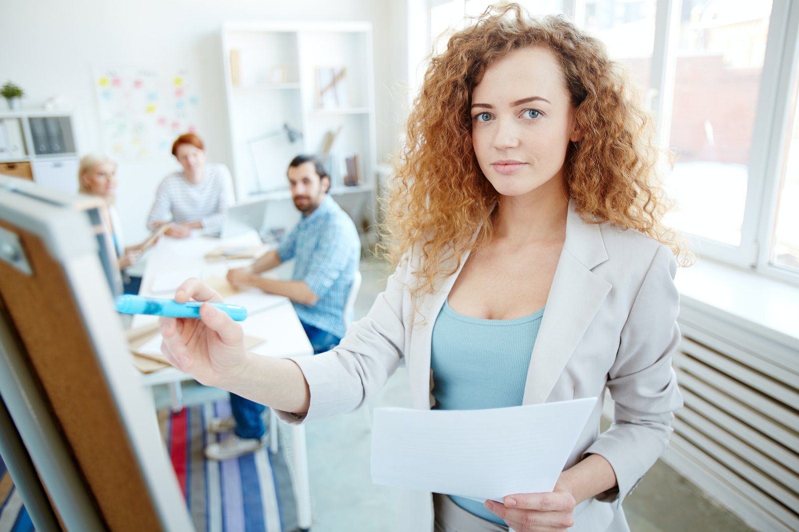 Curly-haired business trainer presenting sales data