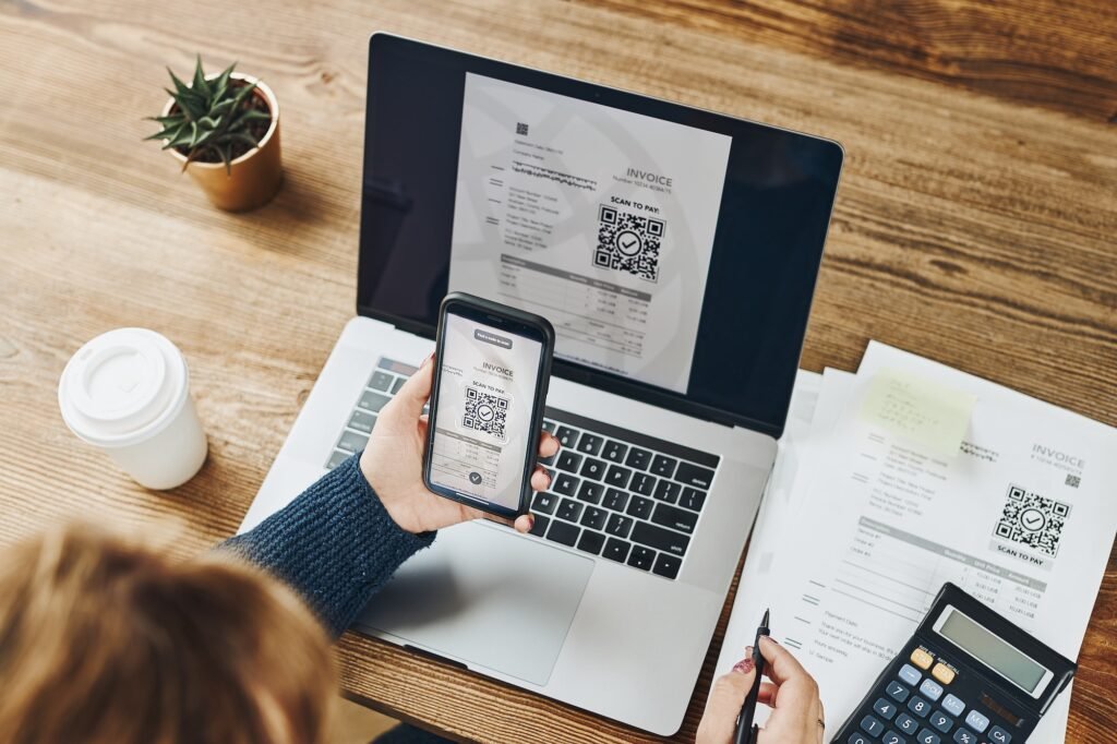 Woman scanning QR code from invoice to make payment using payment app on smartphone. Paying invoice